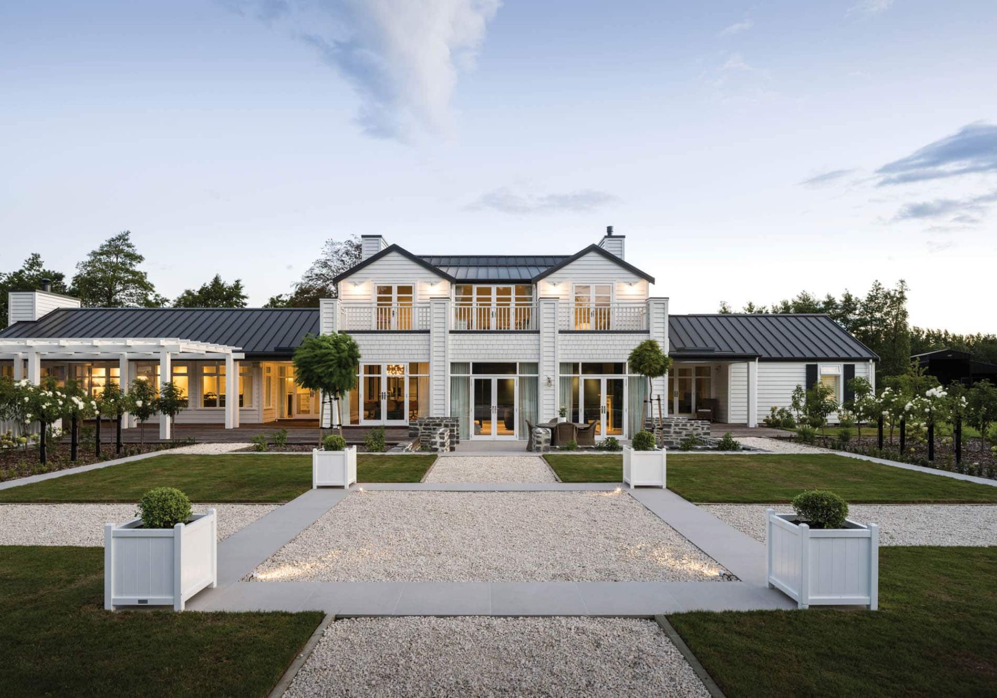 Two-storey white weatherboard country home with dark metal roof and formal courtyard garden, rural Canterbury – Chilton + Mayne architectural designers